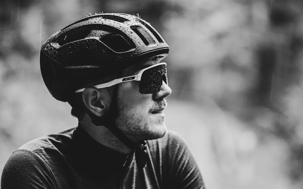 Radfahrer mit Helm und Sonnenbrille im Regen, Schwarzweiss